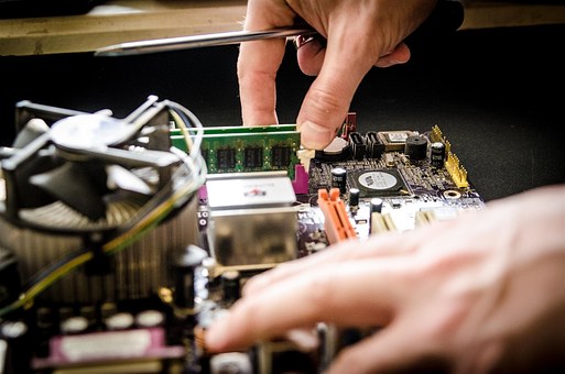 Een technicus opent eencomputer en vervangt een defect onderdeel met een schroevendraaier.